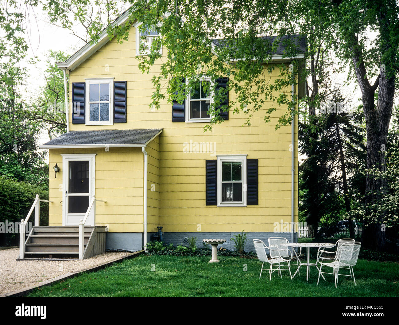 May 1982, yellow wooden detached house, white garden furniture, Long