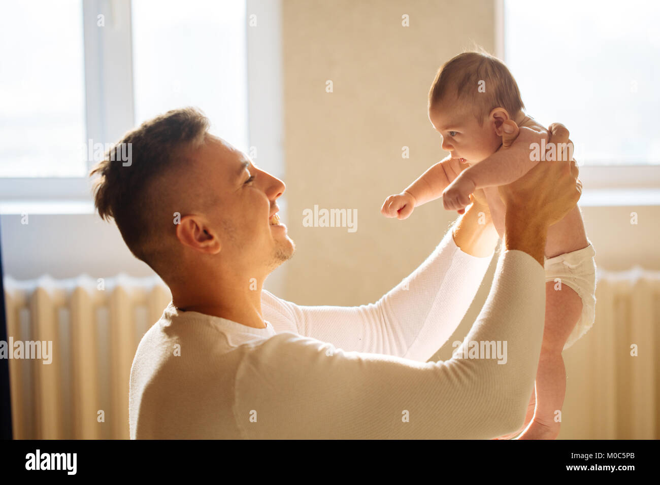 Father lying with cute baby daughter on bed Stock Photo - Alamy