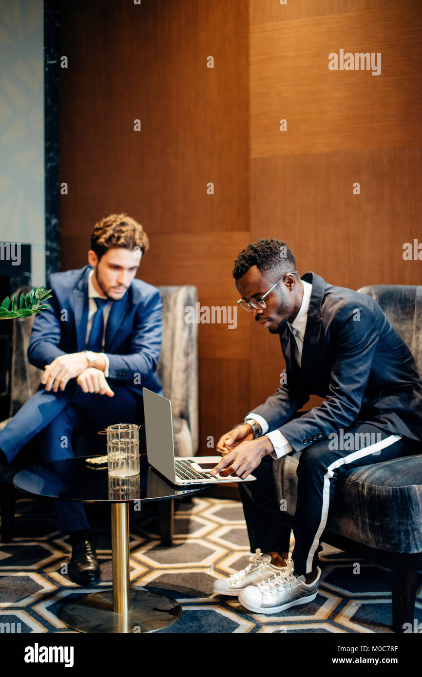 Discuss Info businessman using laptop to discuss information with colleague in ...