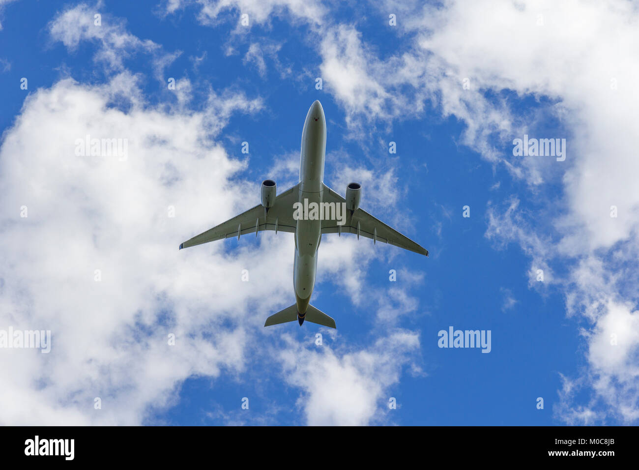 Airplane flies against a background of white clouds Stock Photo - Alamy