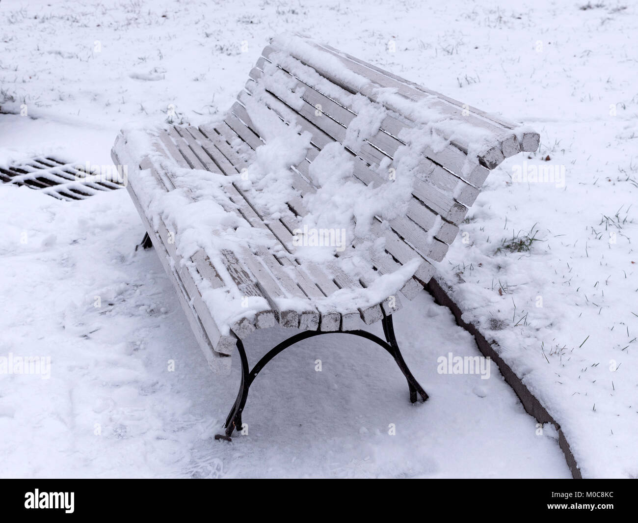 Bench in the park covered with snow Stock Photo - Alamy