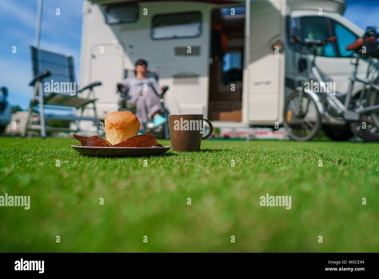 Muffin and Coffee Mug on grass. Caravan car Vacation. Family vacation travel, holiday trip in motorhome VR Stock Photo