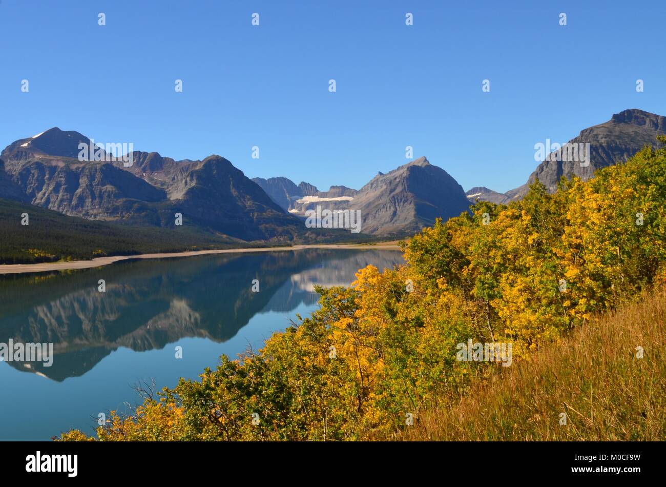 A calm clear day with a wonderful reflection of the mountains in the water, at Many Glaciers, Montana, USA Stock Photo