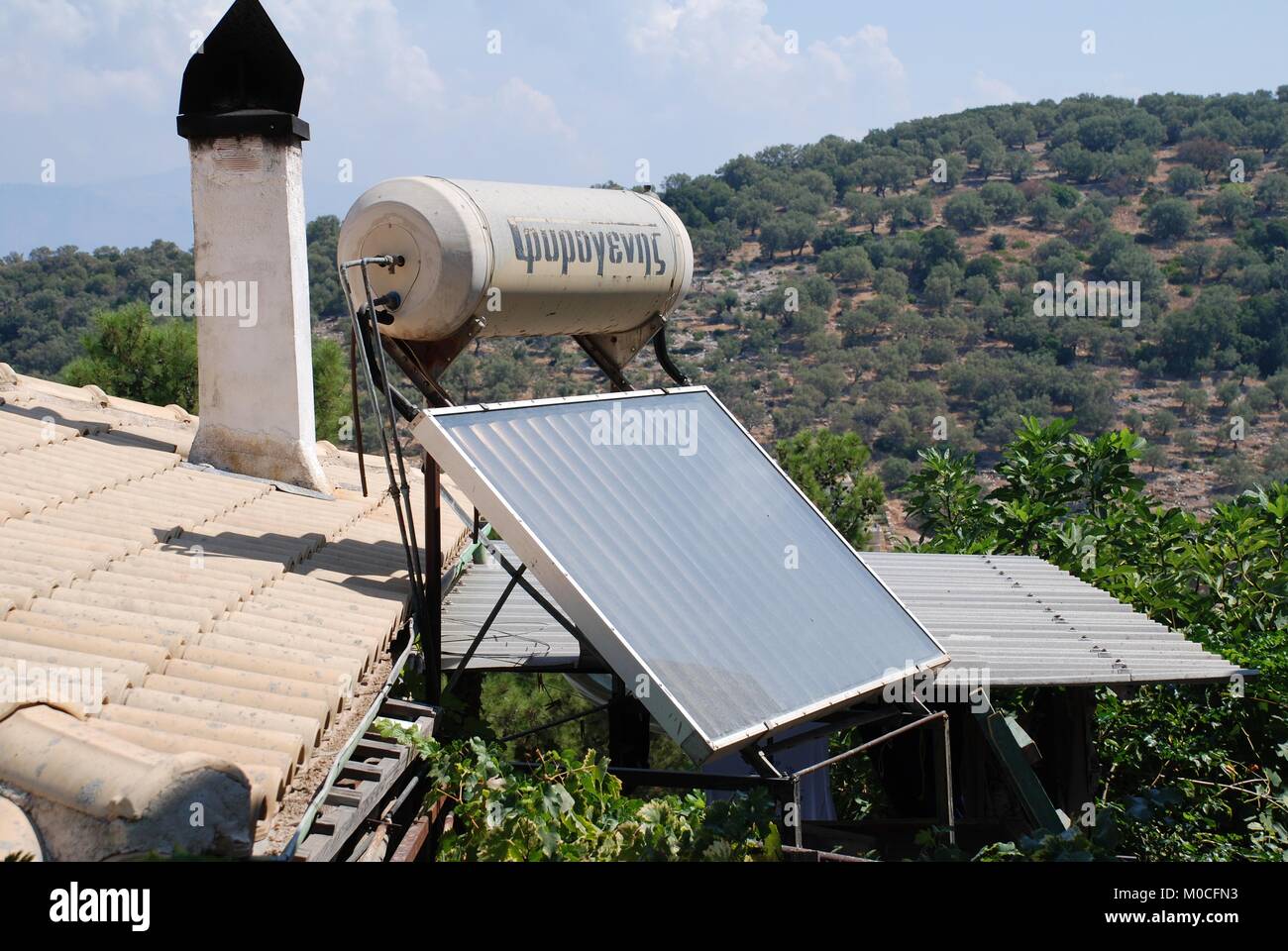 A solar energy panel and water tank on a roof at Spartohori on the Greek island of Meganissi on August 31, 2008. Stock Photo