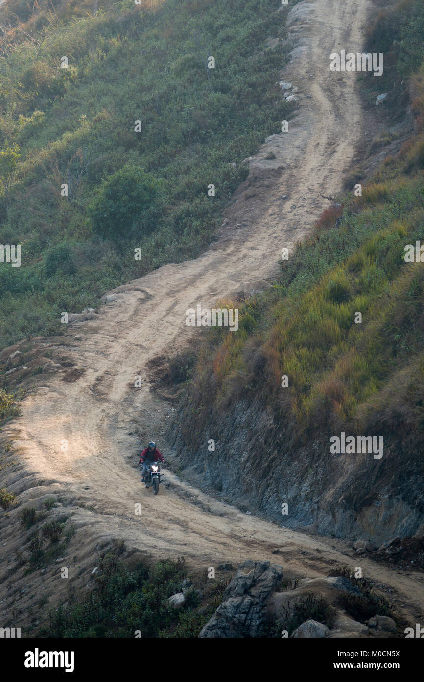 Riding motorbike on dirt road in Bandipur, Nepal Stock Photo