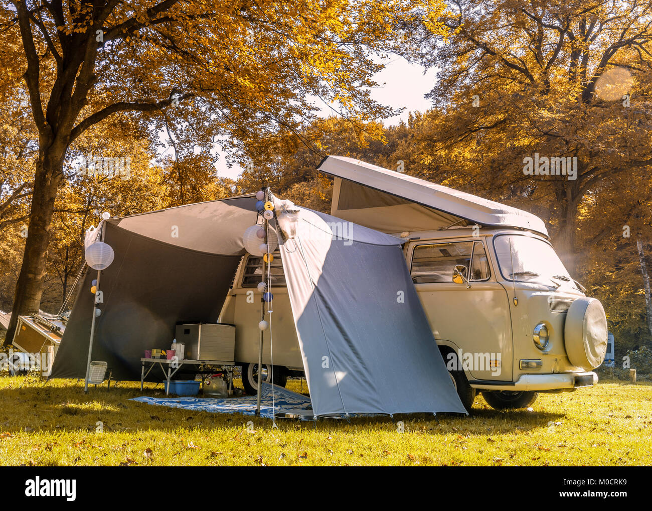 old camper van in the forest during autumn Stock Photo