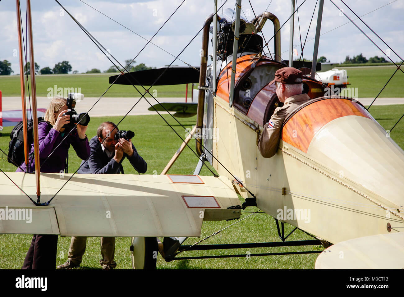 Press photographers taking shots of the pilot of a rebuilt BE2 biplane Stock Photo