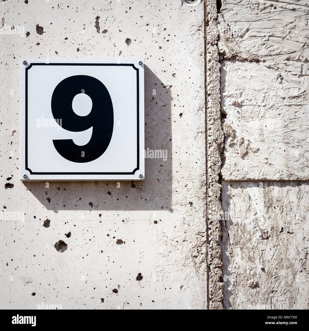Number 9 on textured concrete wall Stock Photo