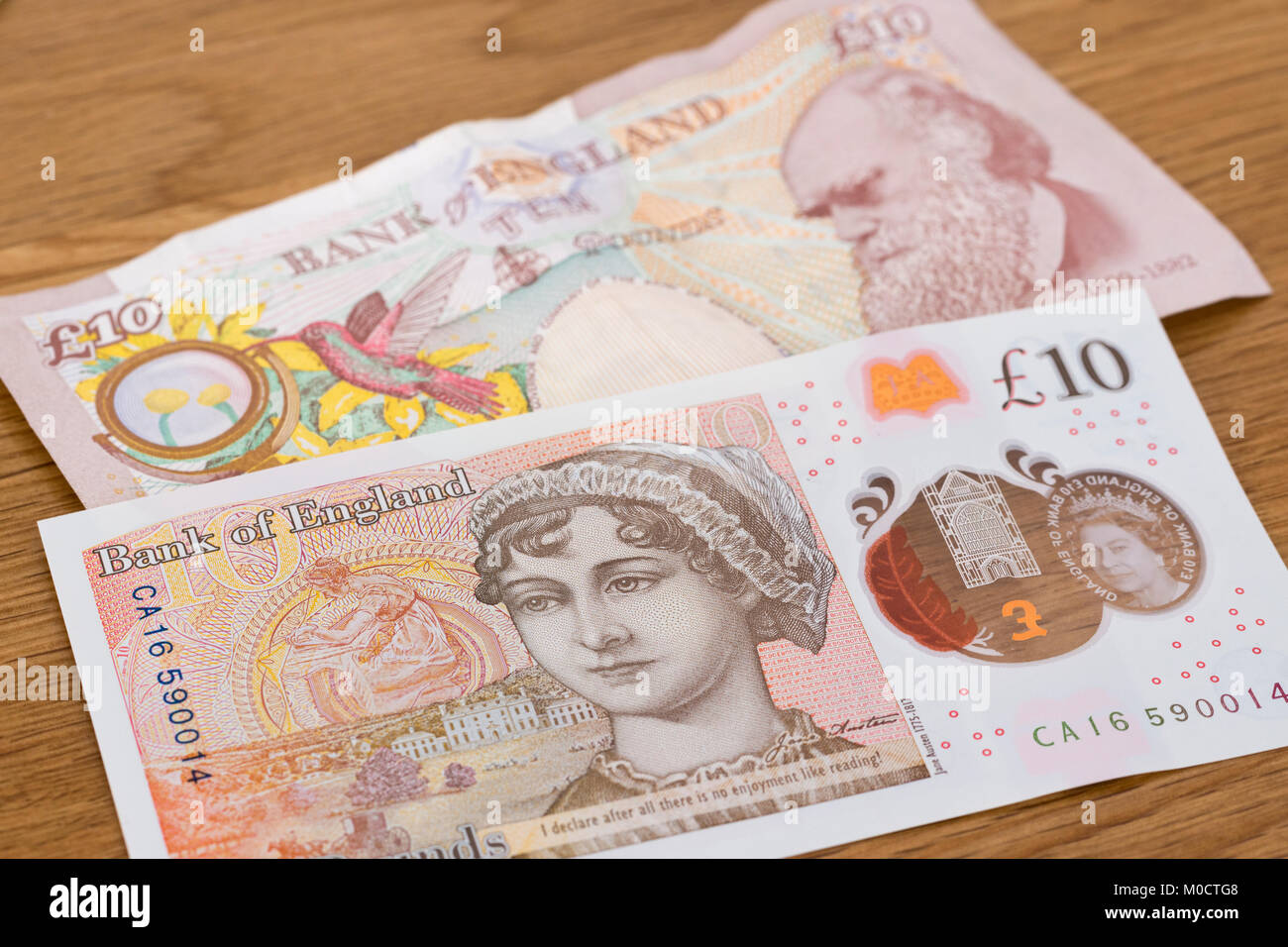 A new ten pound polymer note featuring Jane Austen overlaying an old ten pound paper note featuring Charles Darwin Stock Photo