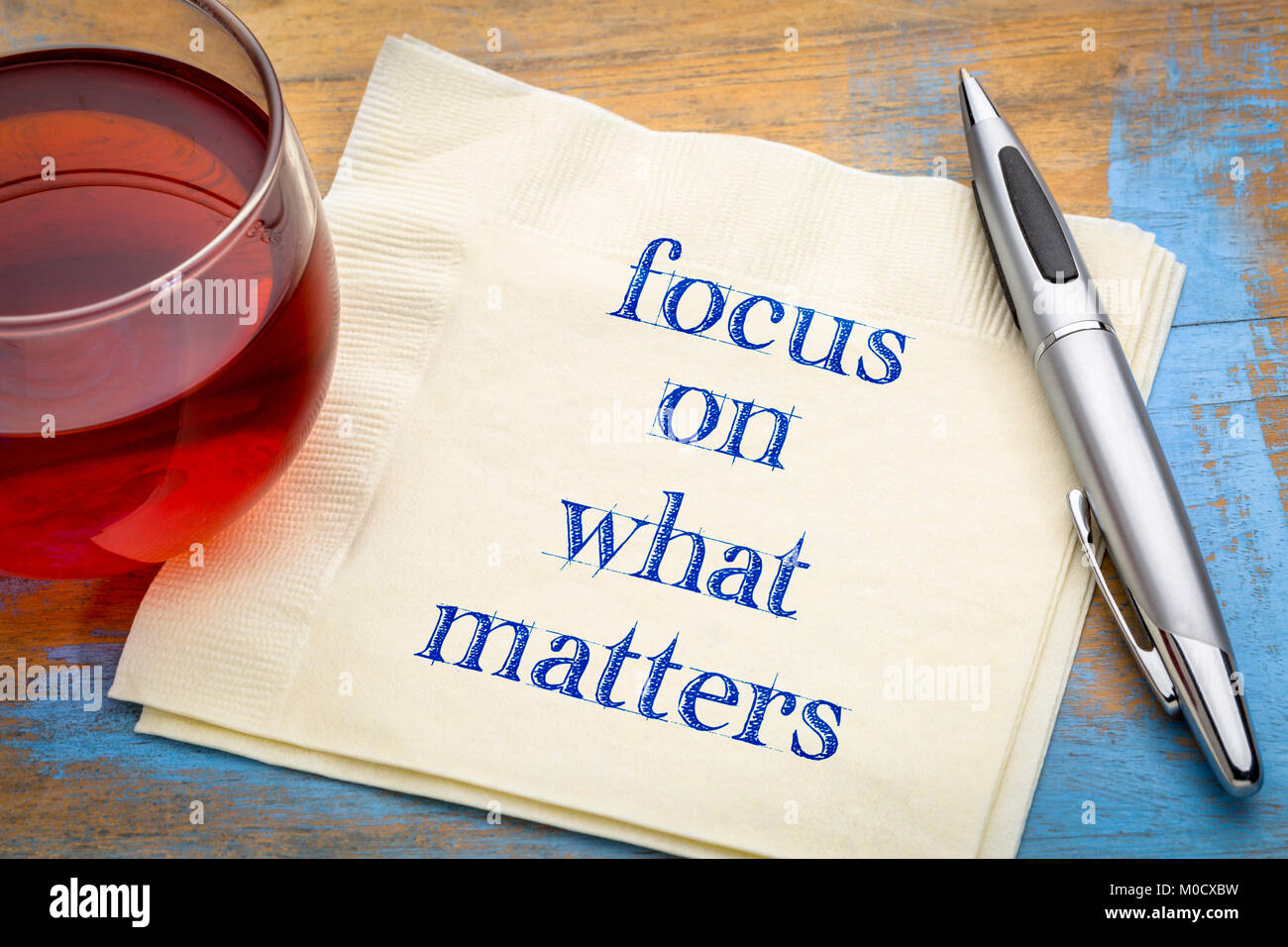 Focus on what matters reminder - handwriting on a napkin with a cup of tea Stock Photo