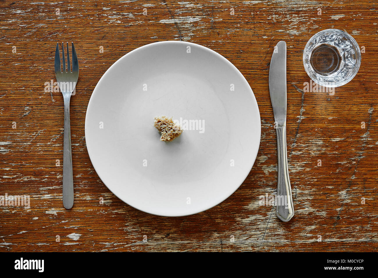 small bread crumb on plate hunger starvation and malnutrition Stock
