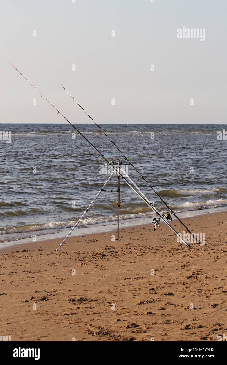 fishing rods set up at sandy beach Stock Photo