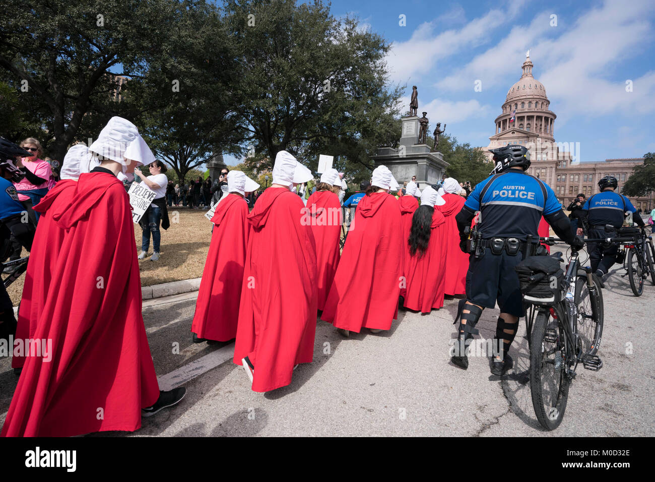 Women dressed as characters from Margaret Atwood's book 'A Handmaid's Tale' participate in a rally at the Texas Capitol in Austin commemorating the first anniversary of the Women's March on Washington and policies they oppose enacted during President Donald Trump's first year in office. Stock Photo