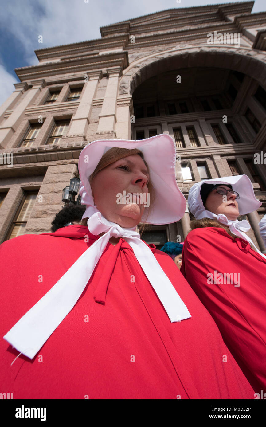Women dressed as characters from Margaret Atwood's book 'A Handmaid's Tale' participate in a rally at the Texas Capitol in Austin commemorating the first anniversary of the Women's March on Washington and policies they oppose enacted during President Donald Trump's first year in office. Stock Photo