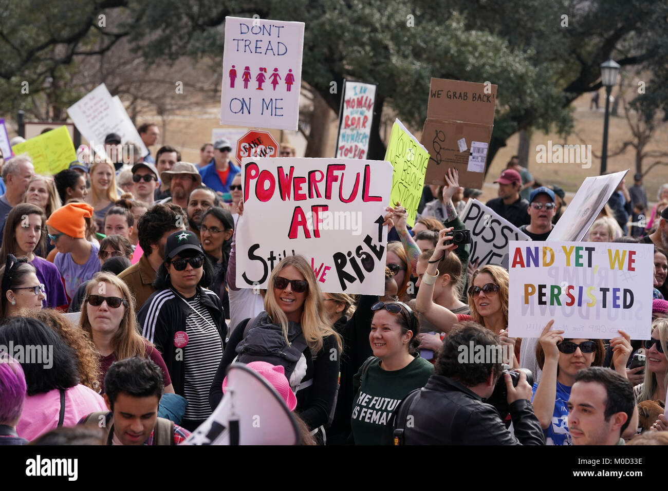 Protesters hold signs as Texas women and men hold a protest rally at the Texas Capitol in Austin on the first anniversary of the Women's March on Washington and a year after President Donald Trump's inauguration. Stock Photo