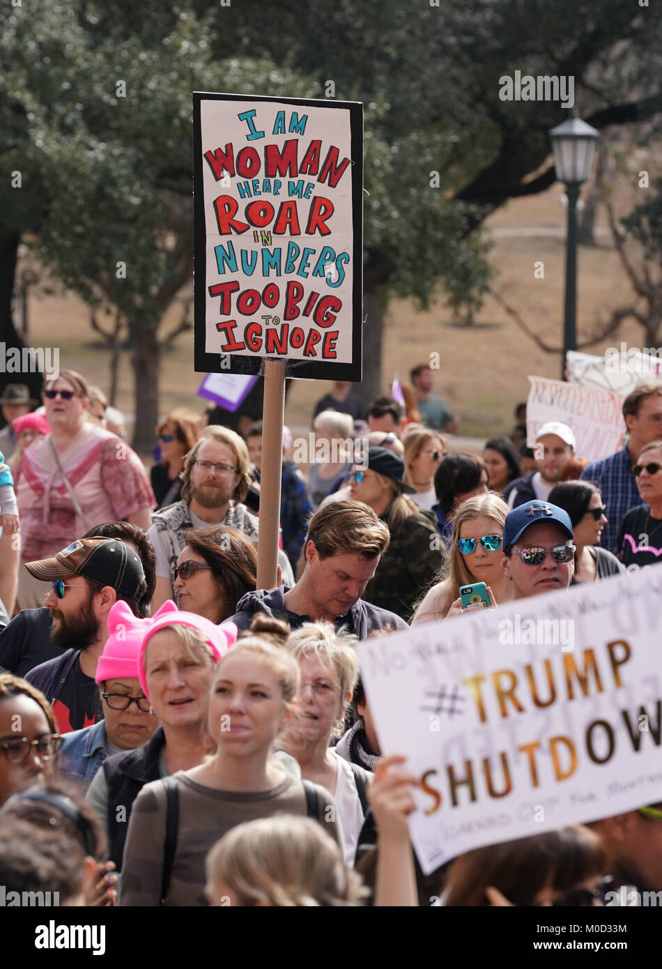 Protesters hold signs as Texas women and men hold a protest rally at the Texas Capitol in Austin on the first anniversary of the Women's March on Washington and a year after President Donald Trump's inauguration. Stock Photo