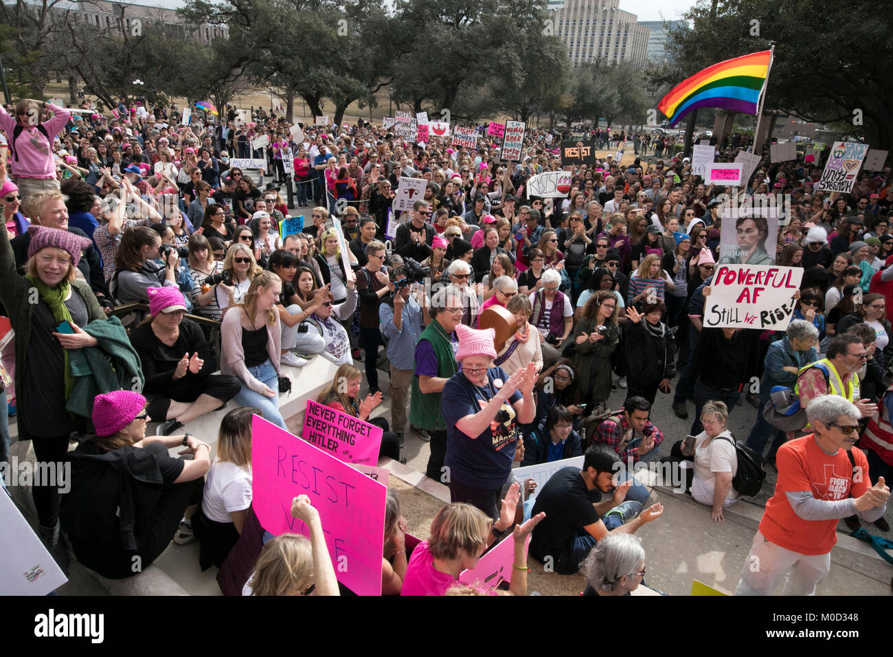 Protesters hold signs while listening to speakers at a protest rally at the Texas Capitol in Austin on the first anniversary of the Women's March on Washington and a year after President Donald Trump's inauguration. Stock Photo