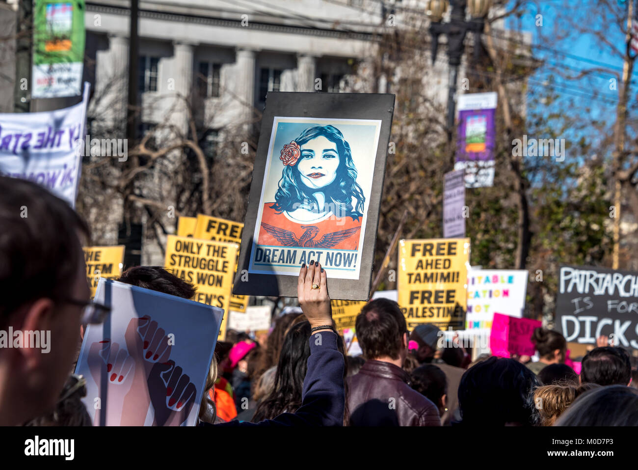 San Francisco, California, USA. 20th January, 2018. The 2018 Women's March in San Francisco, organized by Women's March Bay Area. As protesters march down Market Street, a woman in the crowd holds up a sign for 'Dream Act Now,' calling for action about the 'Dreamers' and DACA. Stock Photo