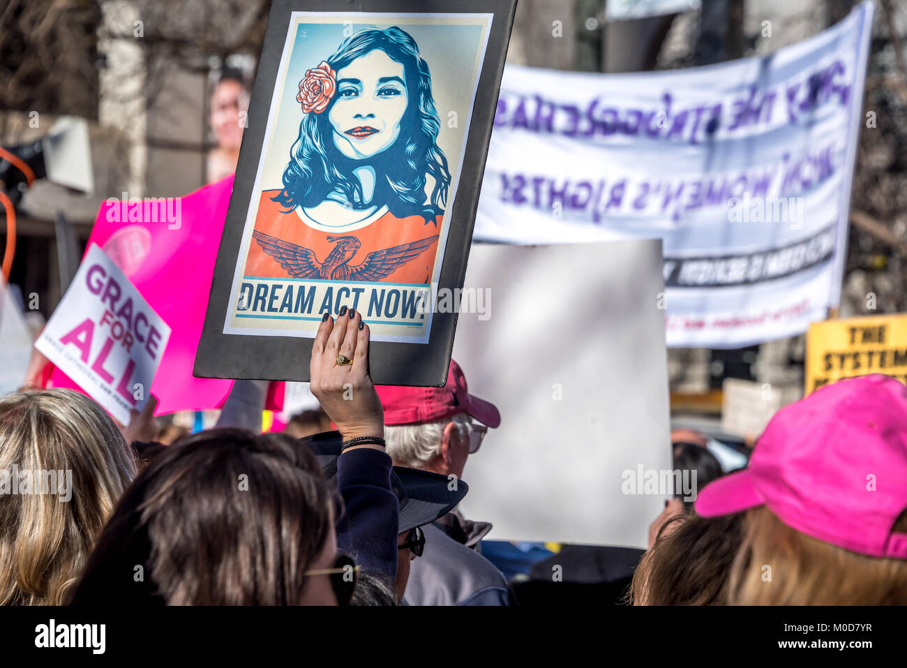 San Francisco, California, USA. 20th January, 2018. The 2018 Women's March in San Francisco, organized by Women's March Bay Area. As protesters march down Market Street, a woman in the crowd holds up a sign for 'Dream Act Now,' calling for action about the 'Dreamers' and DACA. Stock Photo