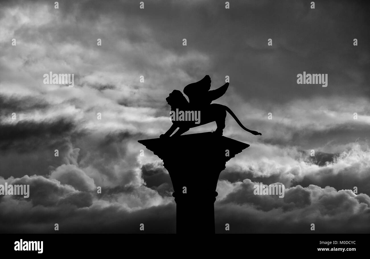 Saint Mark Winged Lion old medieval statue silhouette among clouds Stock Photo