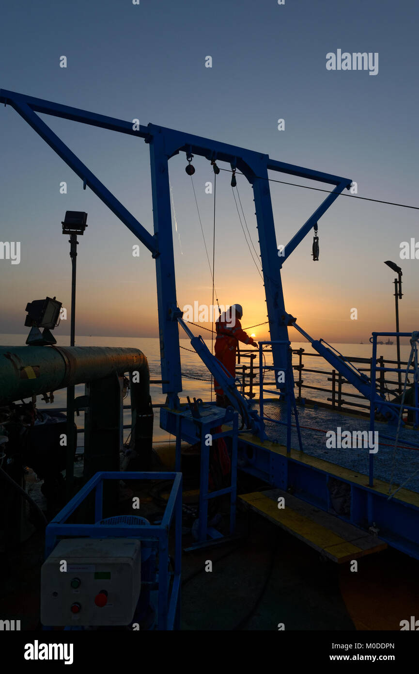 Offshore personnel deploy transponders in the Caspian Sea from the back  deck of a vessel using an A frame. Stock Photo