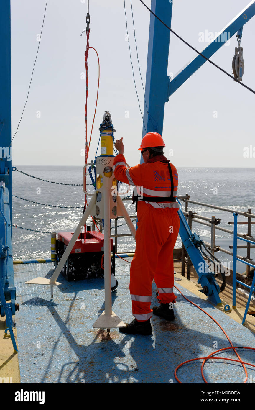Offshore personnel deploy transponders in the Caspian Sea from the back  deck of a vessel using an A frame. Stock Photo