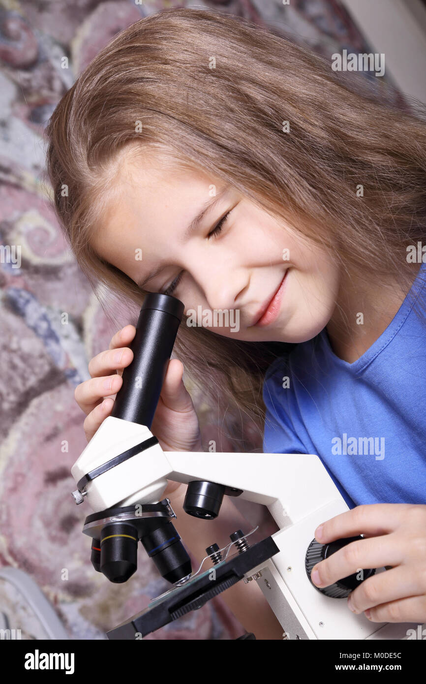 Girl with interest looking through a microscope Stock Photo - Alamy