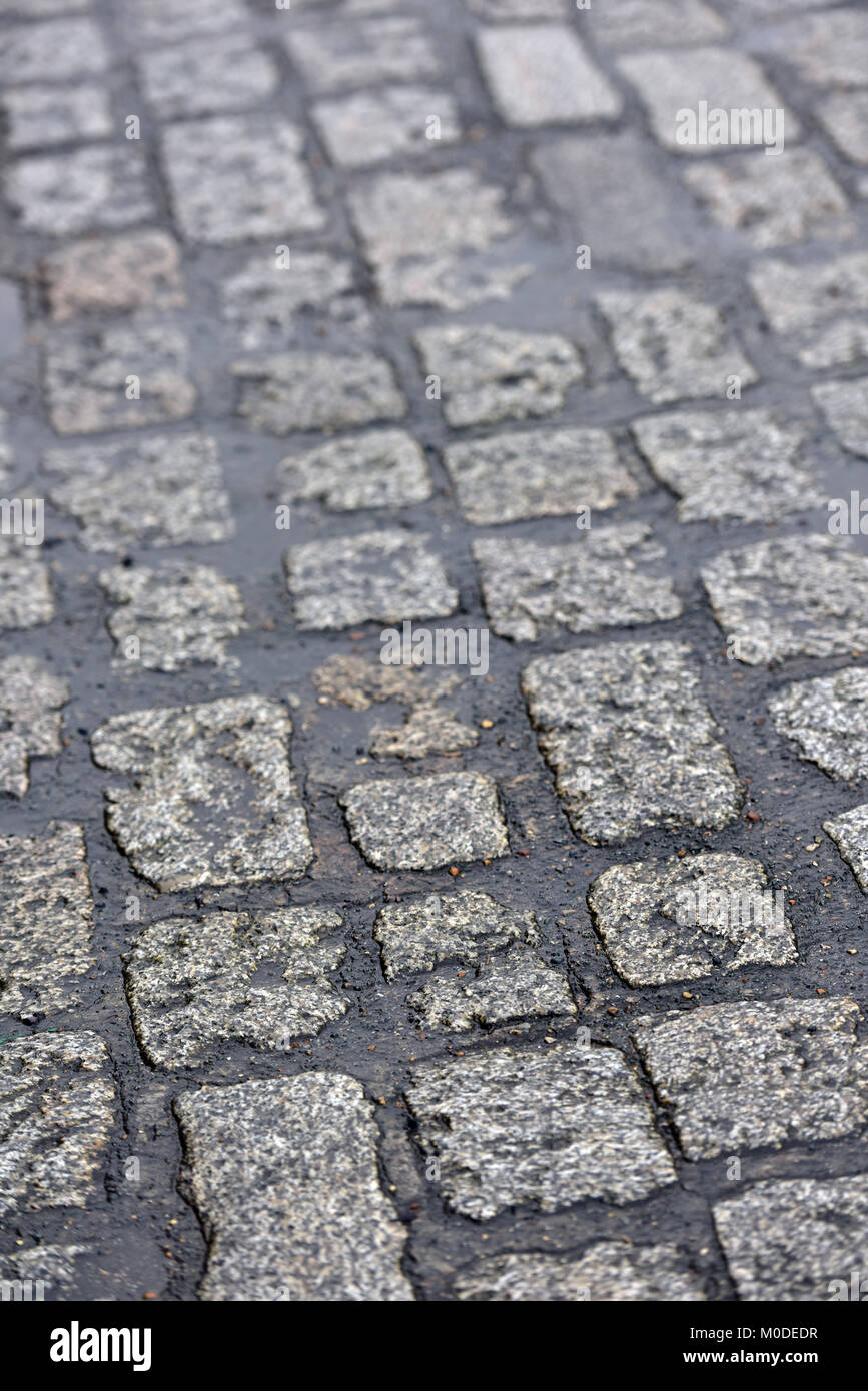 Cobble stones on a Victorian cobbled street. Large old street cobbles making a pattern on an old fashioned road or highway surface. Bumpy ride. Stock Photo