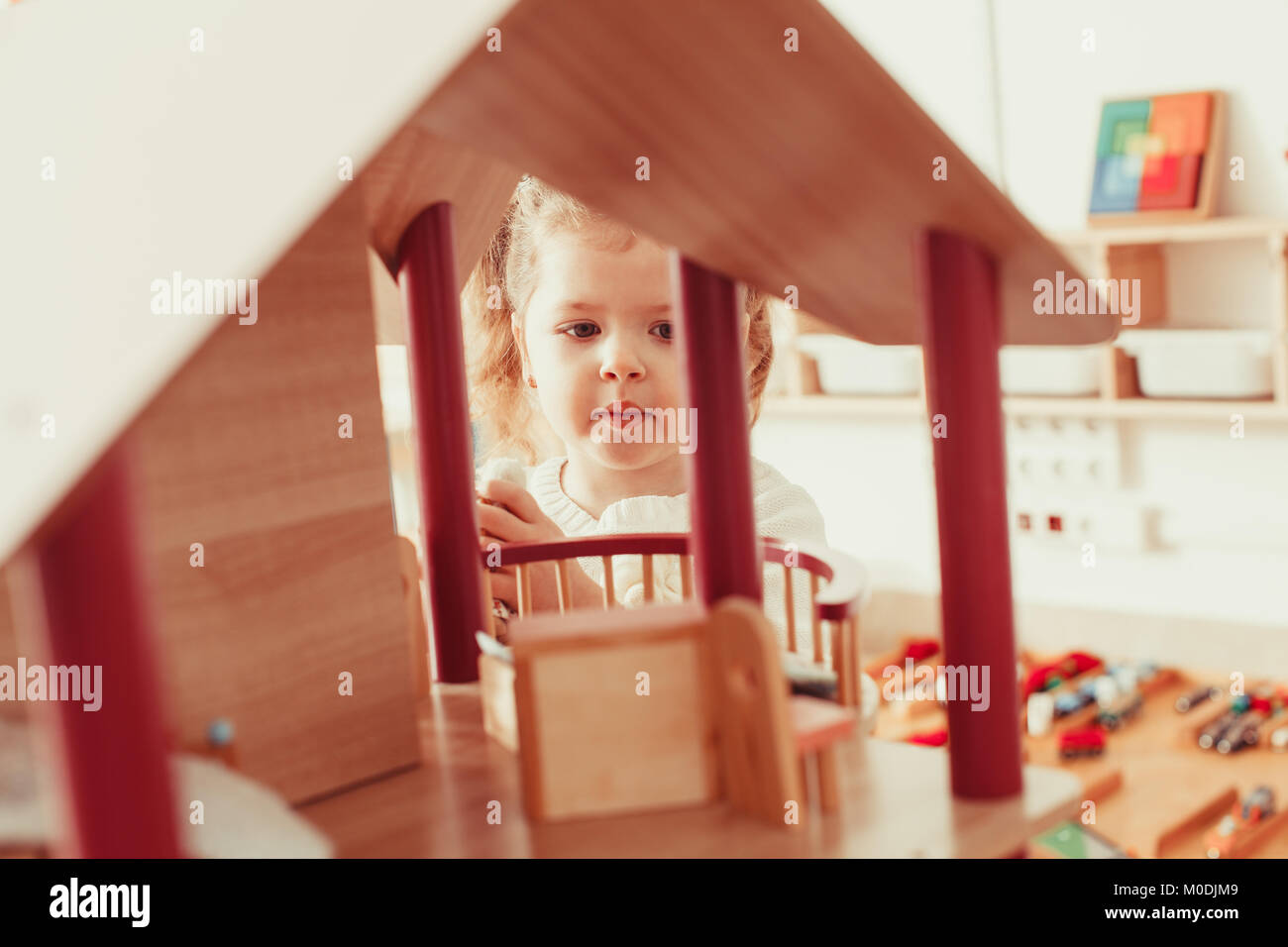 Girl playing with a dollhouse Stock Photo - Alamy