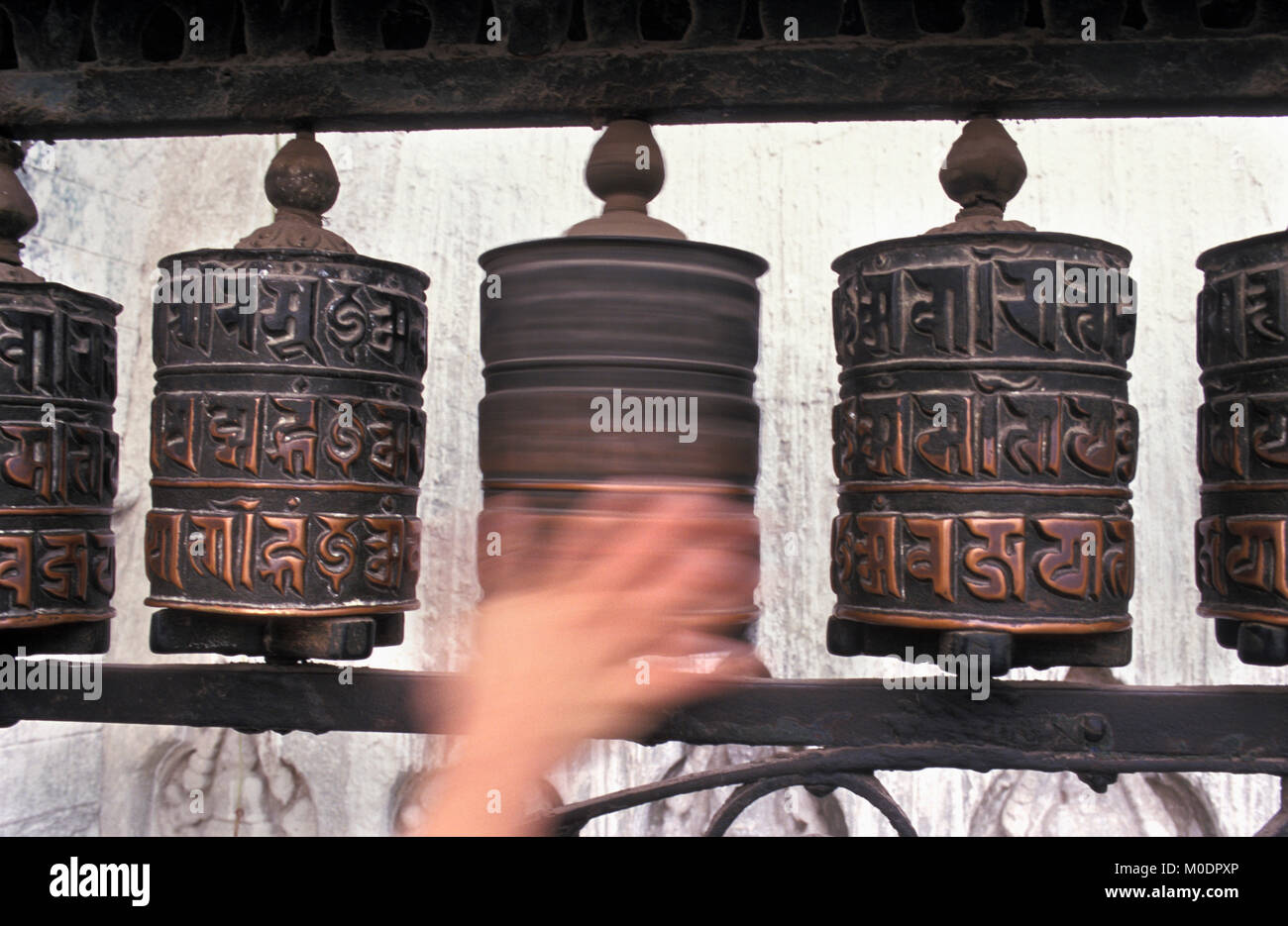 Nepal, Kathmandu. Swayambhunath temple, stupa (Buddhism). Hand spinning prayer wheel. Stock Photo