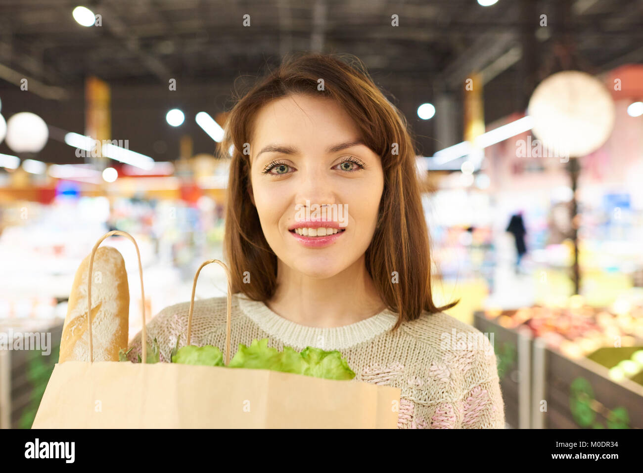 Charming Young Woman Holding Grocery Bag Stock Photo