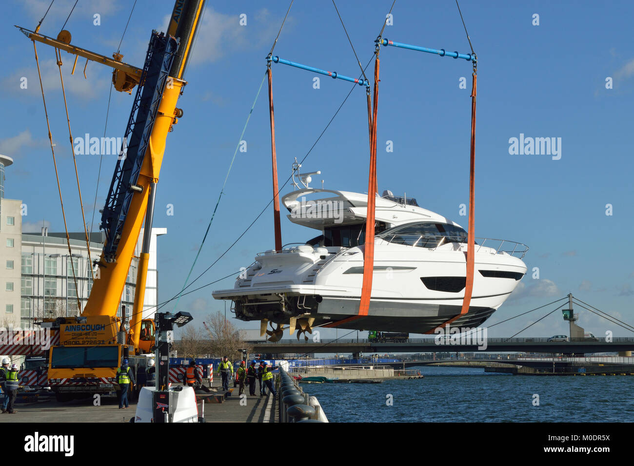 Crane lifting boats back in to the water after they have attended the 2018 London Boat Show held at ExCel London exhibition centre Stock Photo