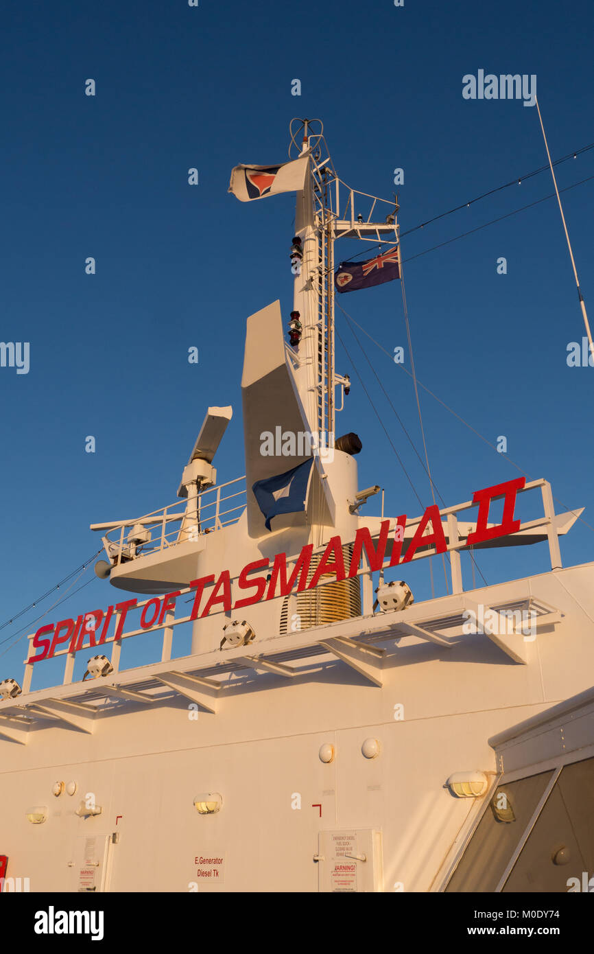 Exterior photos of Spirit of Tasmania II name on bridge in red letters with blue sky and windswept flags and white antennae and radar. Stock Photo