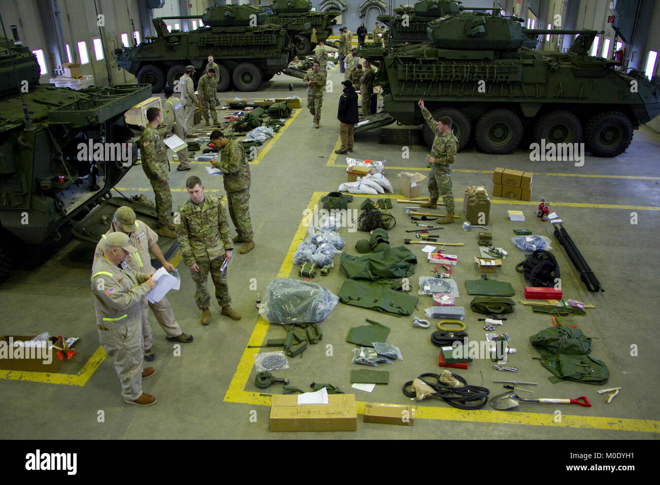 Employees from General Dynamics Land Systems help Soldiers assigned to