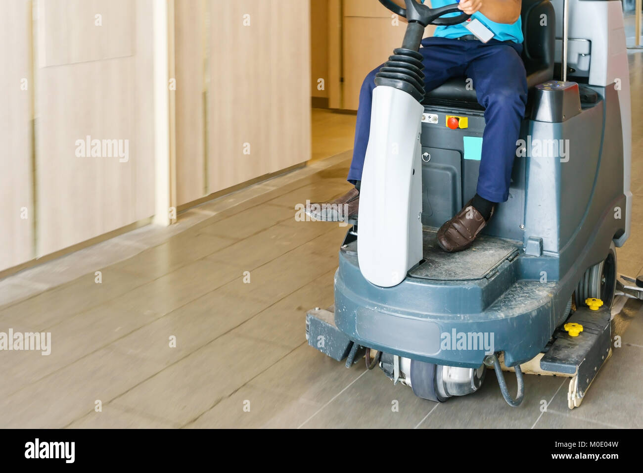 Unidentified Man Operates Rider Floor Scrubber Machine At