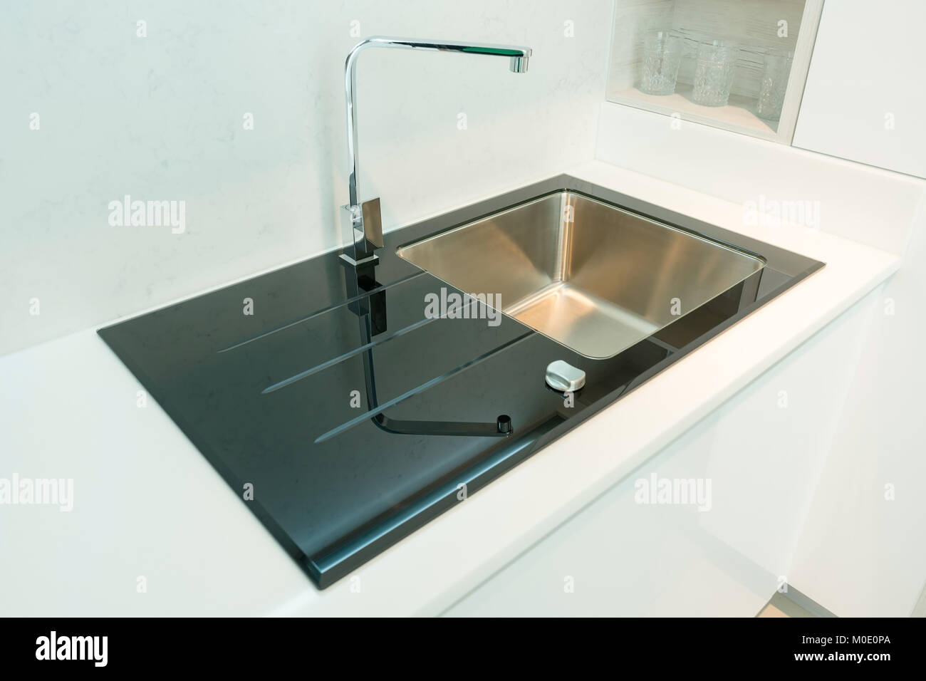 Black kitchen sink and Tap water in the kitchen. The interior of the