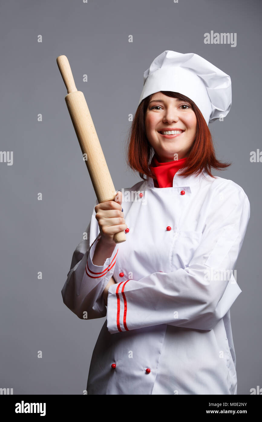 Picture of brunette chef in white robe and cap with rolling pin in ...