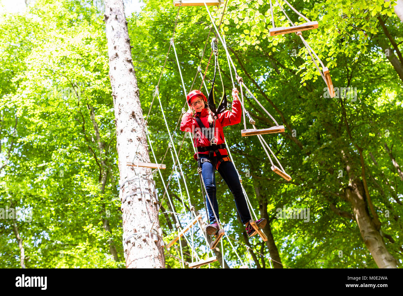 Child reaching platform climbing in high rope course Stock Photo Alamy