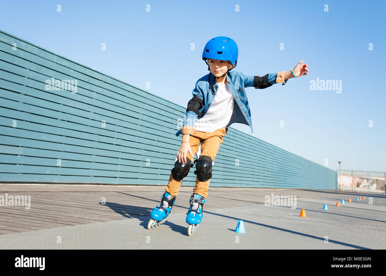 Boy learning to roller skate on road with cones Stock Photo Alamy