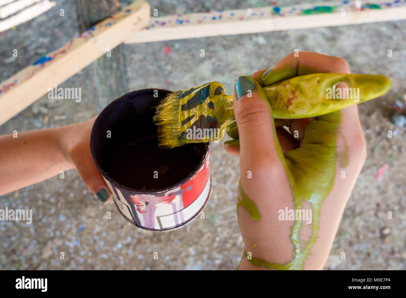Female hand painting colorful wooden structure with brush Stock Photo