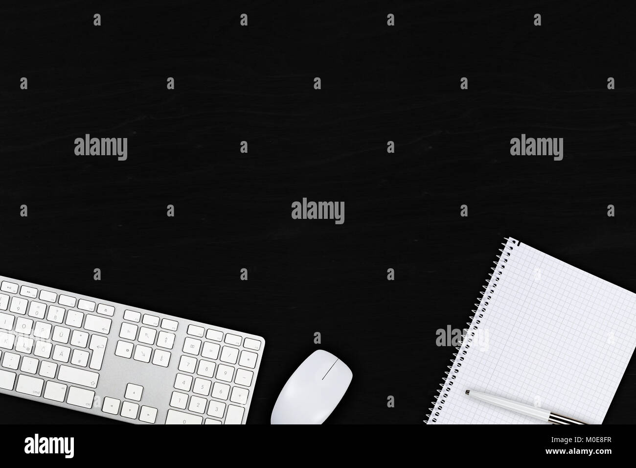 Black wooden office desk top view with computer mouse, keyboard
