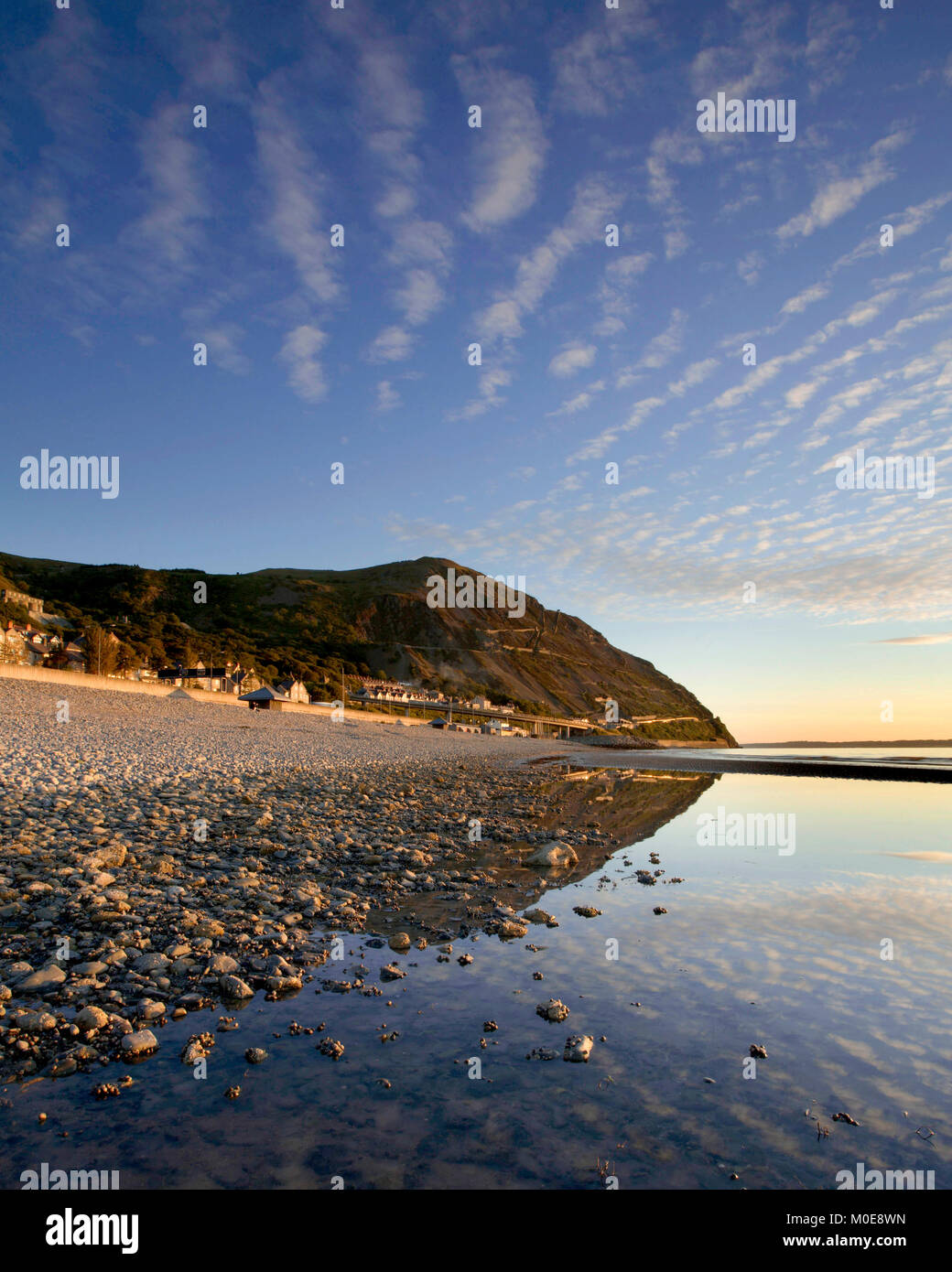 Clouds reflection in pool on stony beach on a sunny day Stock Photo