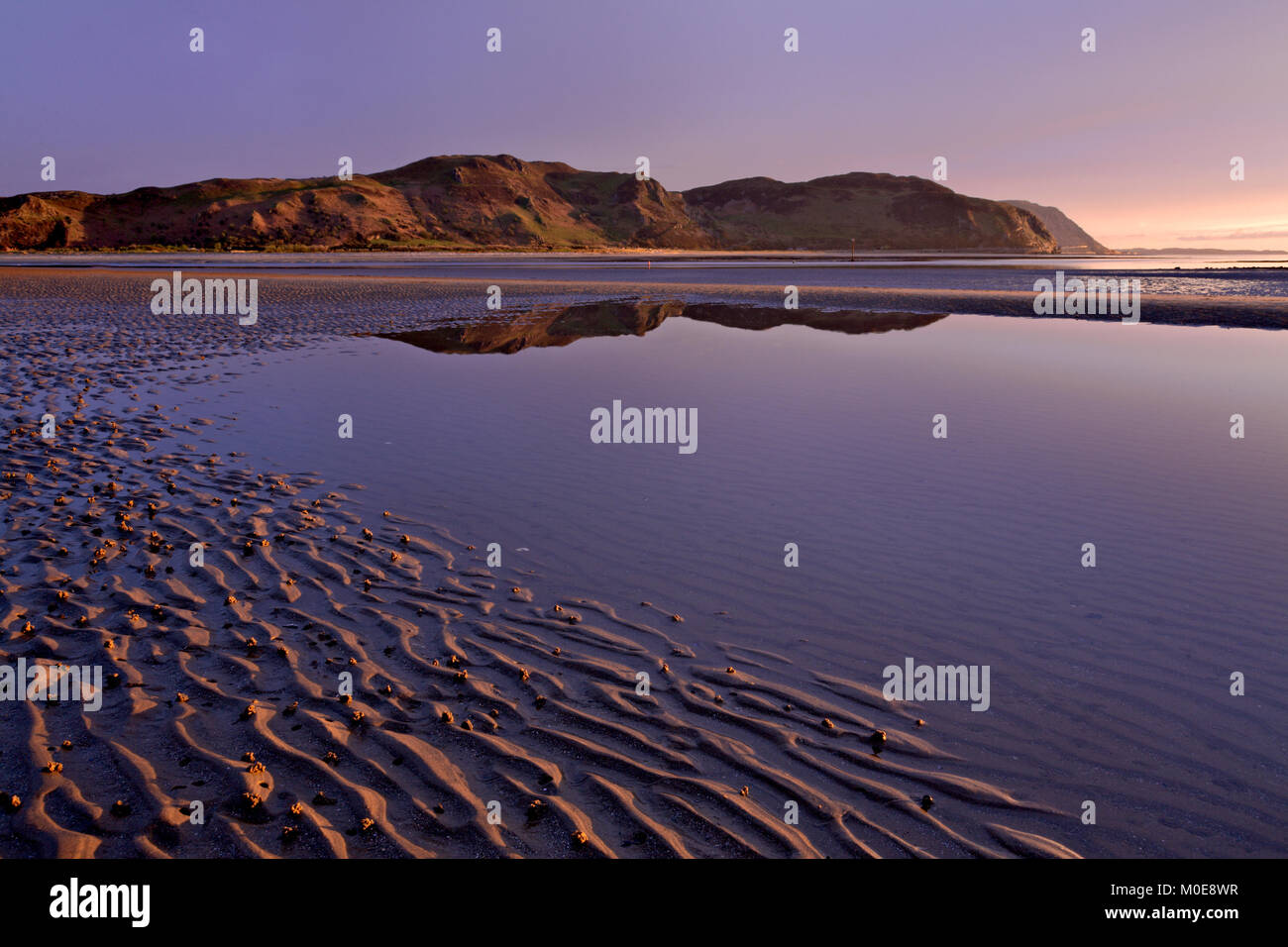 Hills reflecting in tidal pool at sunset on the Nortgh Wales coast at Llandudno Stock Photo