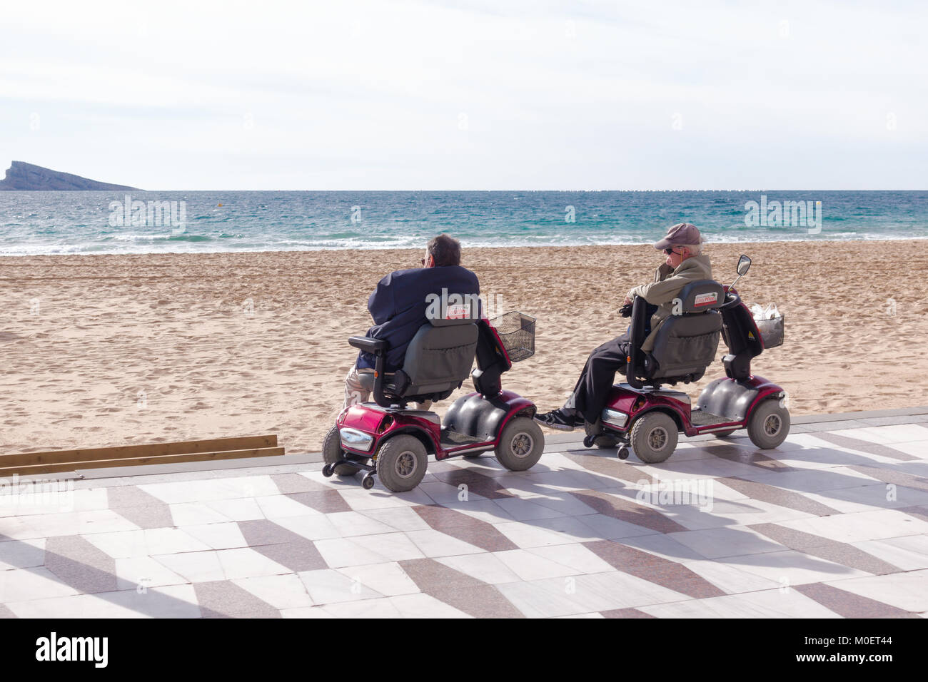 Benidorm, Spain - January 14, 2018: Seniors on mobility scooters looking to the sea in Benidorm, Spain Stock Photo