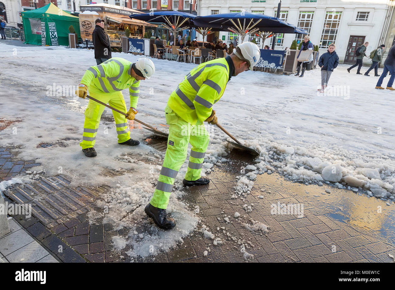 Workmen clearing snow from shopping centre street, Hereford, UK Stock Photo