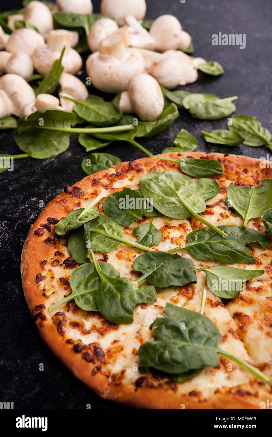 Pizza covered with spinach leaves next to mushrooms Stock Photo Alamy
