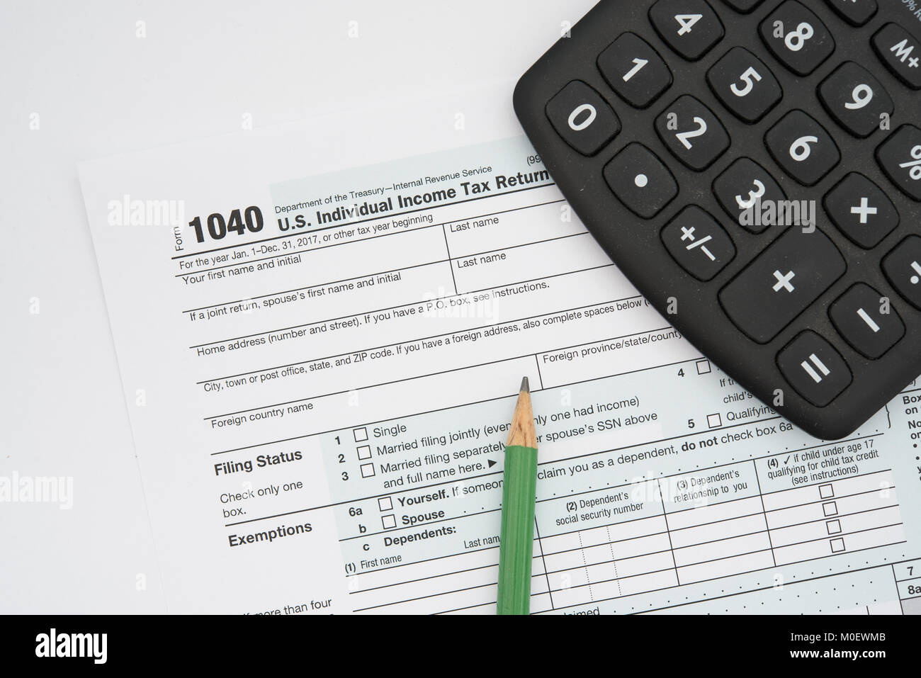 US Federal income tax form 1040 for individuals, with a pencil and a calculator. Stock Photo
