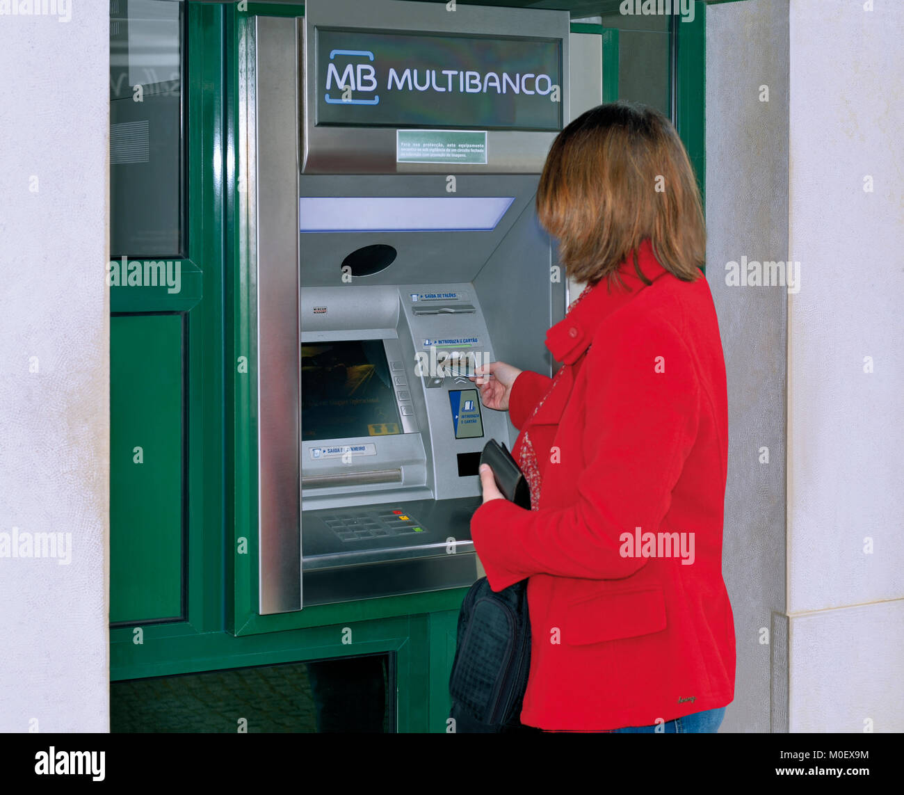 Woman using bank card at cash terminal Stock Photo