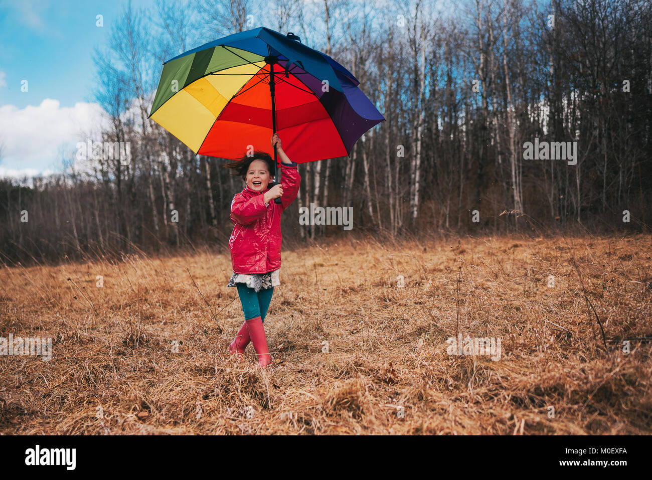 Girl holding an open umbrella on a windy day Stock Photo