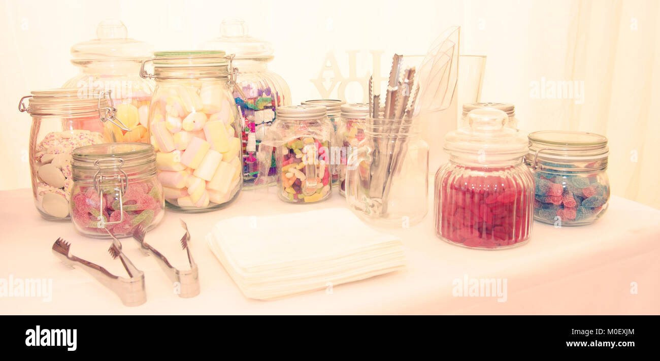 Jars of assorted sweets on a table Stock Photo